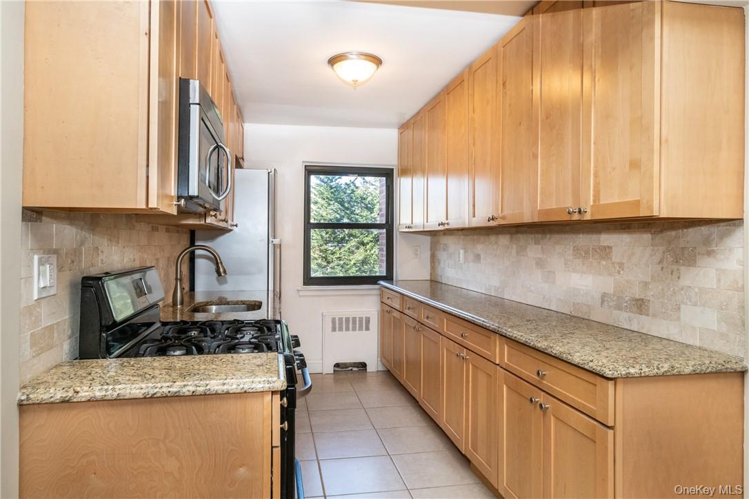 50 White Oak Street, Unit 3G New Rochelle, NY 10801 - Photo 10 of 16 a kitchen with granite countertop cabinets and window
