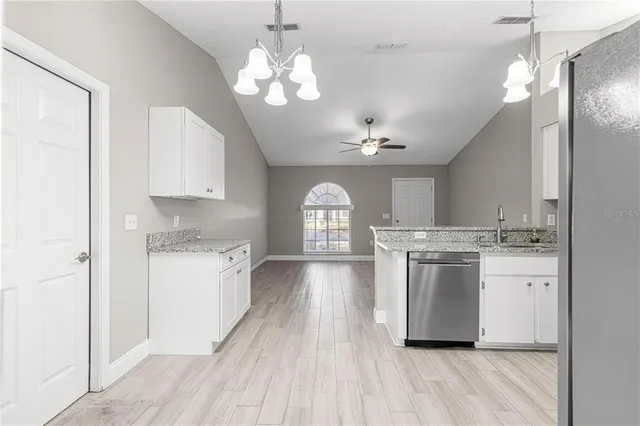 a view of a kitchen with a sink and dishwasher a refrigerator with wooden floor