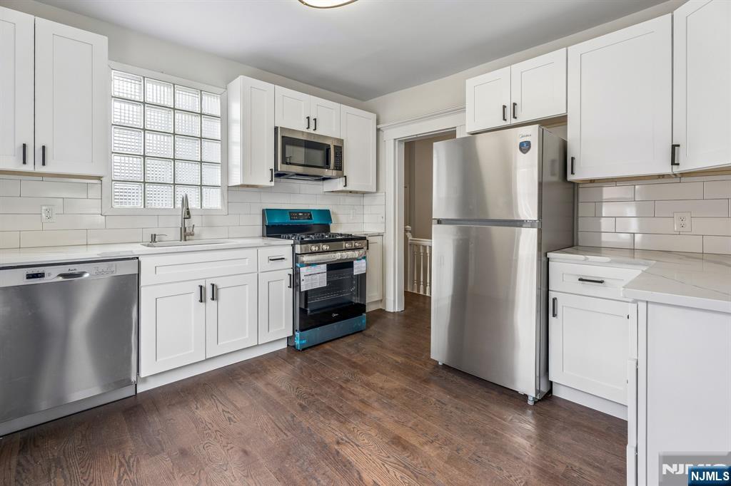 94 Church Street Montclair, NJ 07042 - Photo 22 of 49 a kitchen with white cabinets white stainless steel appliances and sink