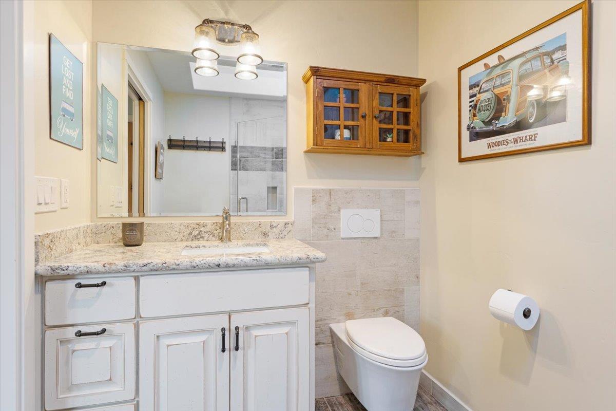 7409 Hihn Road Ben Lomond, CA 95005 - Photo 65 of 101 a bathroom with a granite countertop toilet a sink and a mirror