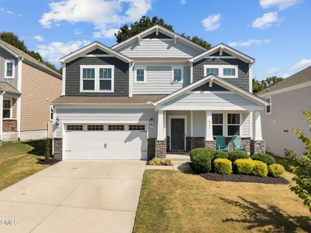 a front view of a house with a yard outdoor seating and garage