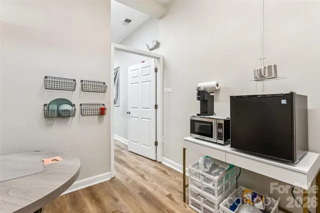 a living room with a flat screen tv and a view of kitchen