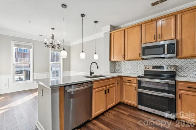 a kitchen with granite countertop a refrigerator stove and microwave