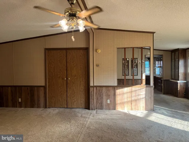 an empty room with a window and a ceiling fan