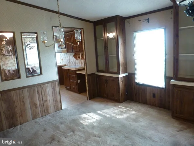 a view of an empty room with window and bathroom