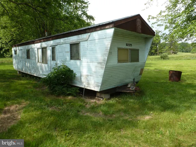 a view of a house with a big yard and large trees