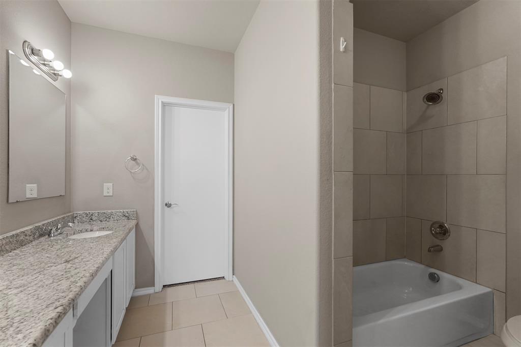 514 East Hazelwood Street, Unit A Princeton, TX 75407 - Photo 15 of 19 a bathroom with a granite countertop sink a mirror and a bathtub