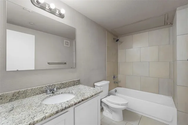 a bathroom with a granite countertop sink a toilet and a mirror
