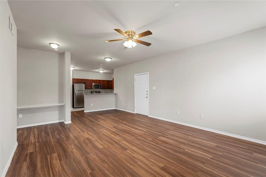 514 East Hazelwood Street, Unit A Princeton, TX 75407 - Photo 3 of 19 a view of an empty room with wooden floor and a ceiling fan