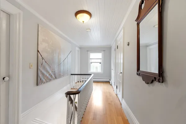 a view of a hallway with wooden floor and staircase