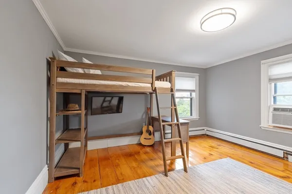 a view of empty room with wooden floor and window