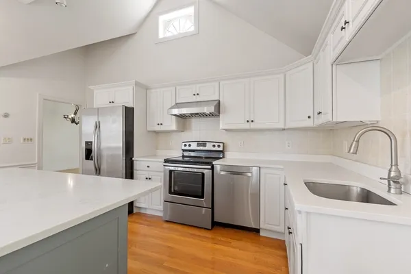 a kitchen with stainless steel appliances granite countertop a sink stove and refrigerator