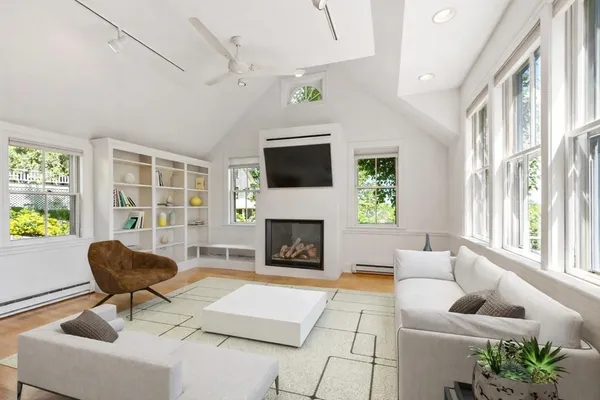 a living room with furniture a fireplace a window and a flat screen tv