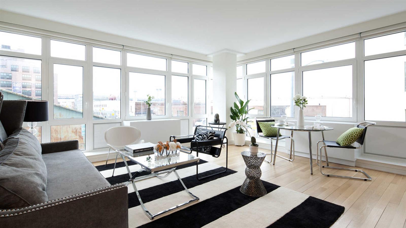 175 Kent Avenue, Unit 403 Brooklyn, NY 11249 - Photo 9 of 9 a living room with furniture and floor to ceiling windows