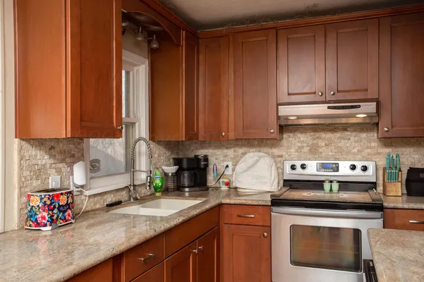 a kitchen with stainless steel appliances granite countertop a sink a stove and cabinets