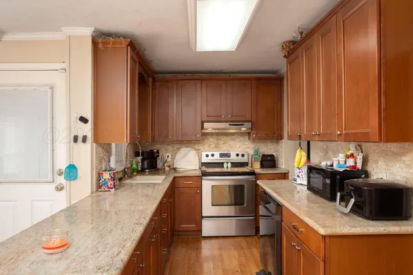 a kitchen with stainless steel appliances granite countertop a sink stove and refrigerator