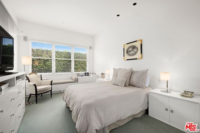 a bedroom with a bed and a large window