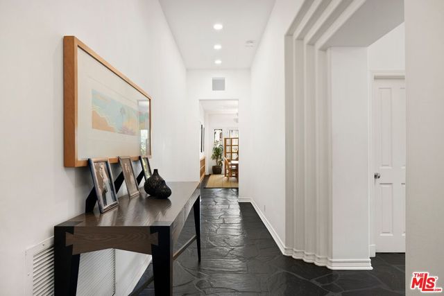 a hallway with wooden floor stairs and furniture