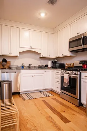 a kitchen with granite countertop a stove top oven and cabinets