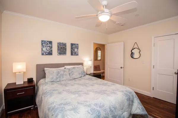 a bedroom with a bed and a lamp on dresser