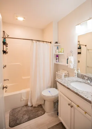 a bathroom with a granite countertop sink toilet and shower
