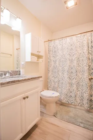 a bathroom with a granite countertop sink toilet and shower