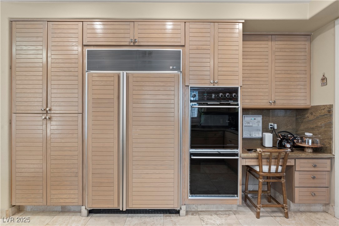 8215 Crow Valley Lane Las Vegas, NV 89113 - Photo 21 of 43 Kitchen with paneled built in refrigerator, backsplash, light stone counters, and built in study area