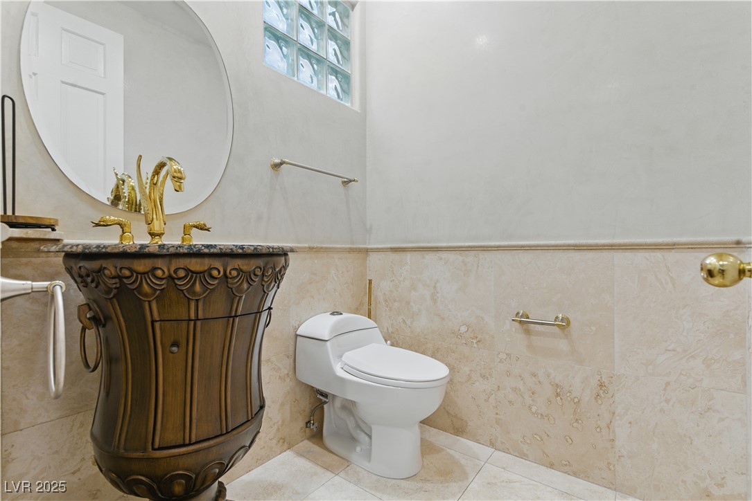 8215 Crow Valley Lane Las Vegas, NV 89113 - Photo 27 of 43 Half bathroom with vanity, tile patterned flooring, and a wainscoted wall