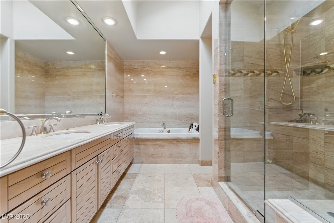 8215 Crow Valley Lane Las Vegas, NV 89113 - Photo 32 of 43 Full bathroom featuring double vanity, a bath, light tile patterned flooring, a stall shower, and tile walls