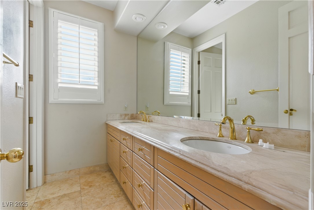 8215 Crow Valley Lane Las Vegas, NV 89113 - Photo 35 of 43 Bathroom with double vanity and light tile patterned floors