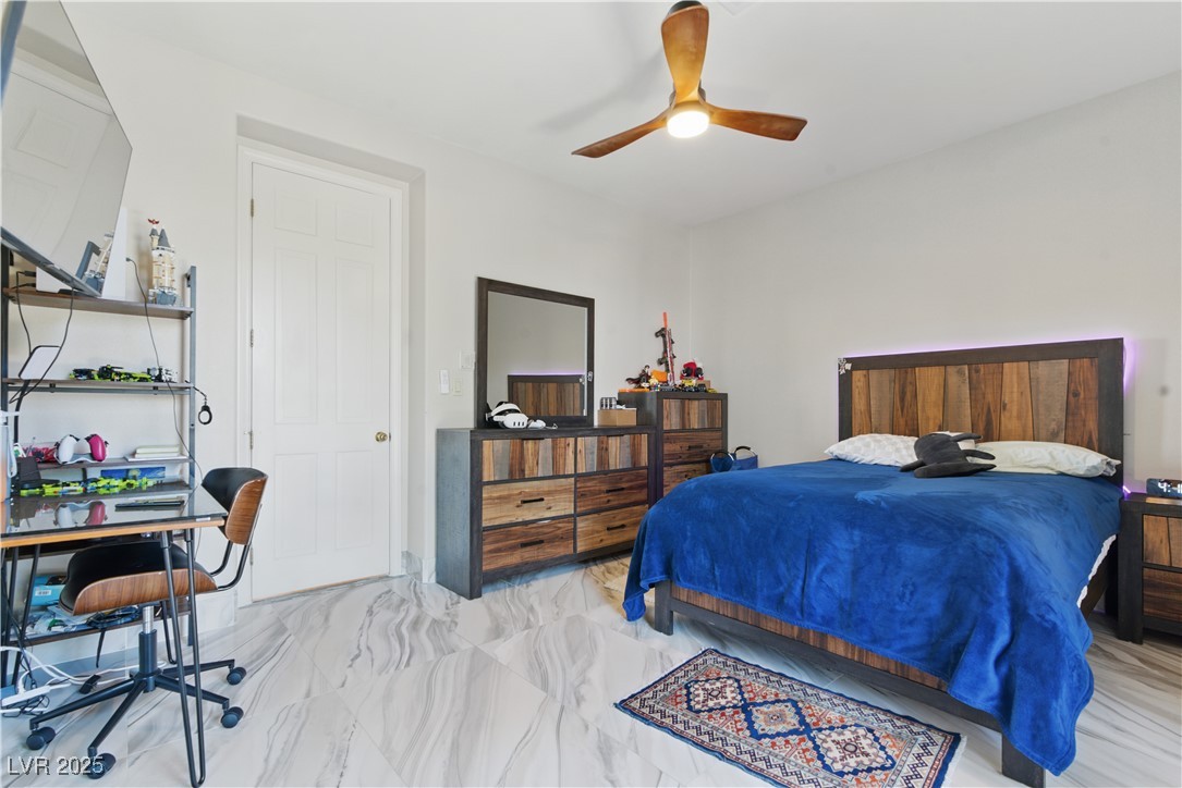 8215 Crow Valley Lane Las Vegas, NV 89113 - Photo 38 of 43 Bedroom with an office area, ceiling fan, and marble look tile flooring