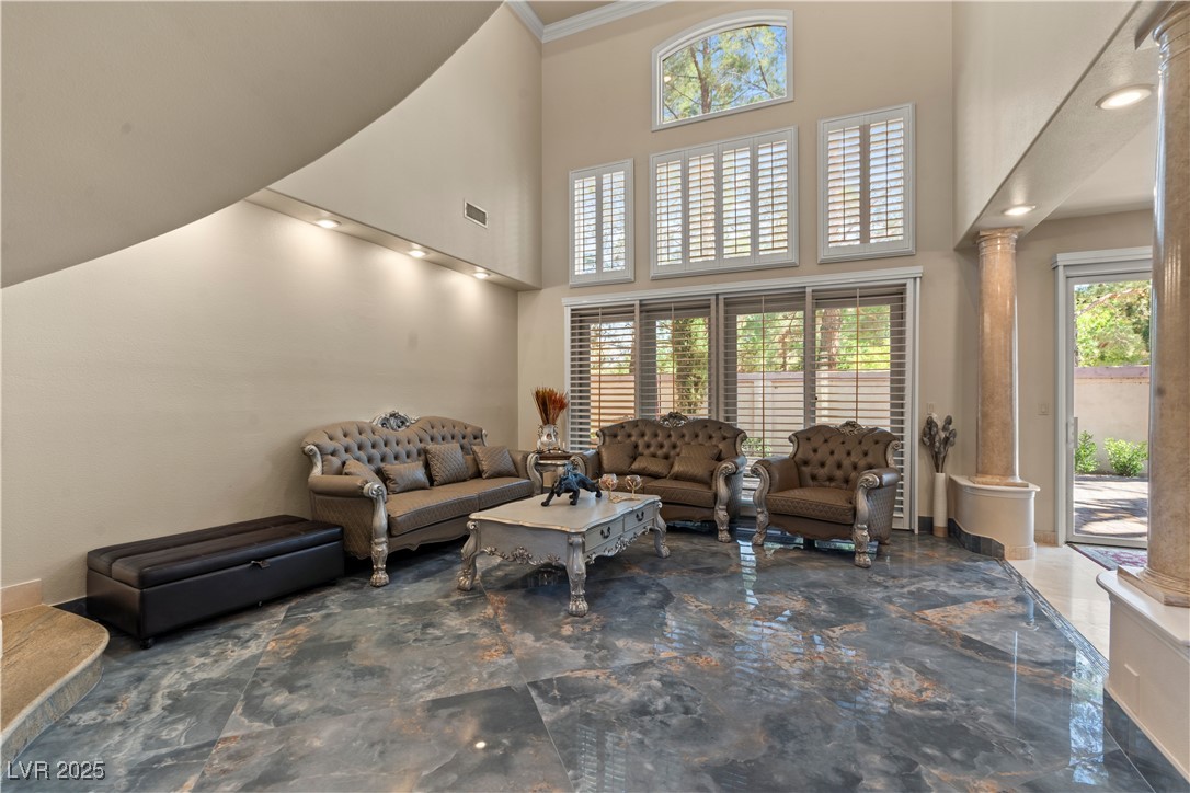 8215 Crow Valley Lane Las Vegas, NV 89113 - Photo 4 of 43 Living room featuring ornate columns, a towering ceiling, dark marble finish floors, and recessed lighting