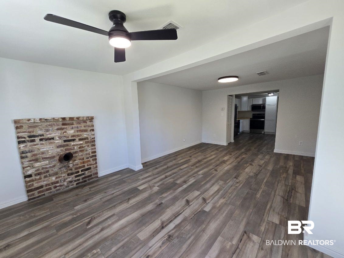 821 Dailey Street Brewton, AL 36426 - Photo 9 of 17 Unfurnished living room with ceiling fan and dark wood-style flooring