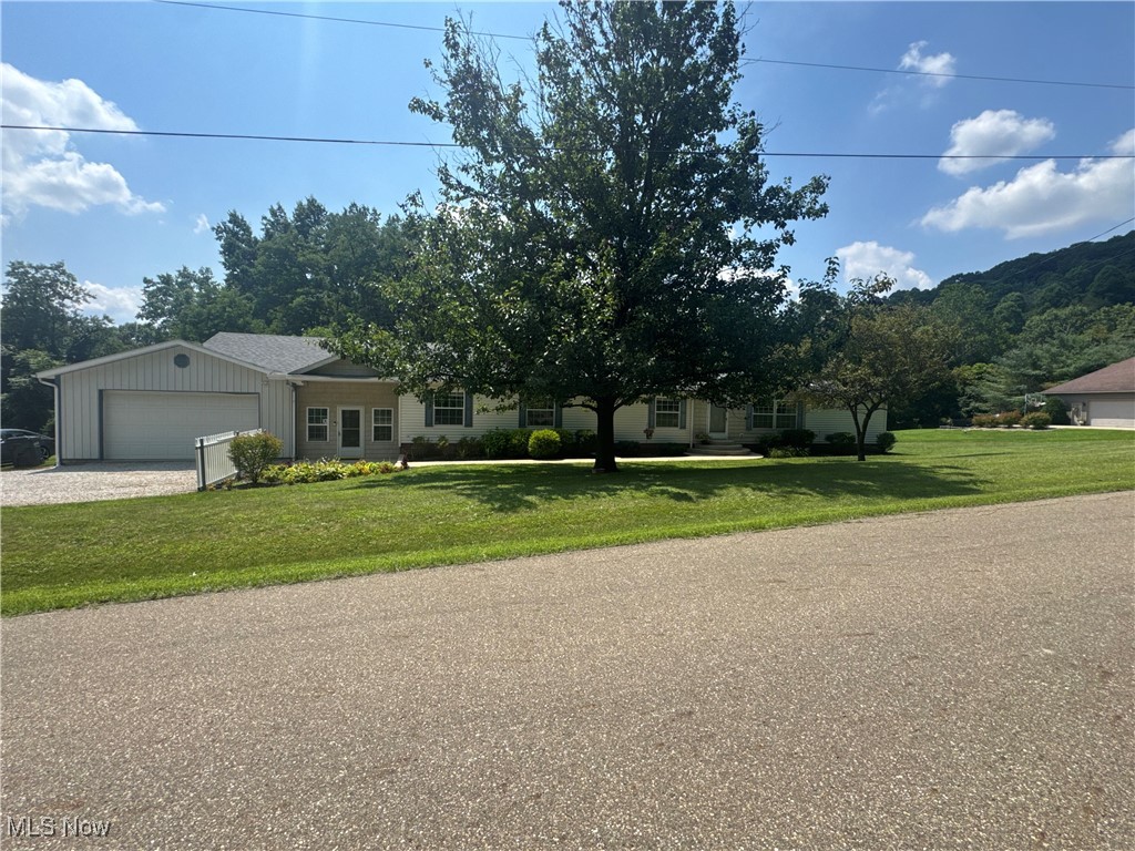 3264 Simpson Road Southeast Dennison, OH 44621 - Photo 1 of 29 View of front of home with an attached garage, a front lawn, and gravel driveway