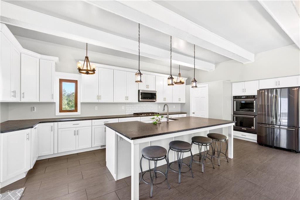 51 Kelley Road Canonsburg, PA 15317 - Photo 18 of 50 There is room for 4 at the island and you could put a table under the TV if you wanted. You can also see the double oven from this view. All appliances were new in 2020 when the kitchen was installed