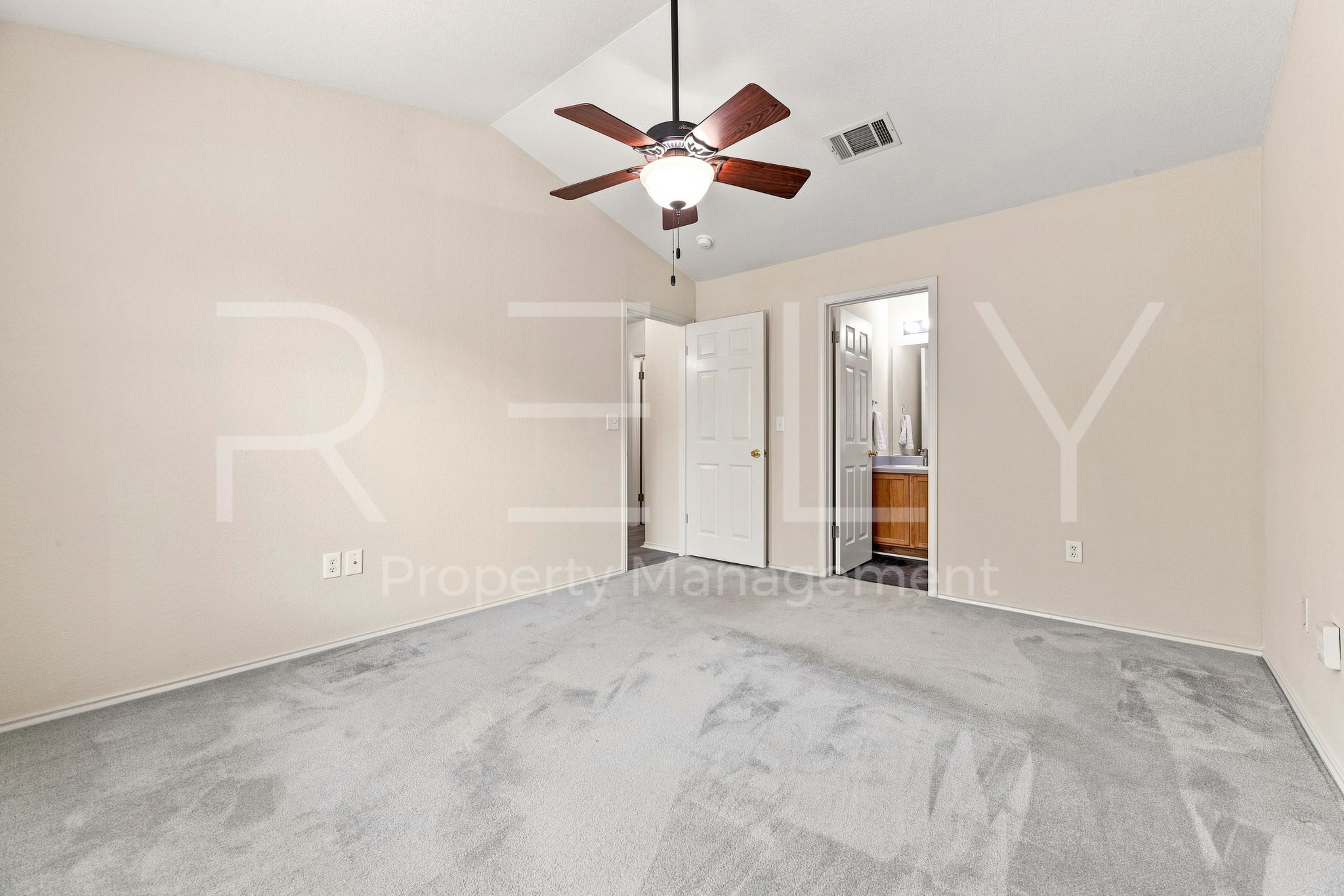 103 Prairie Springs Loop Georgetown, TX 78626 - Photo 17 of 33 A vaulted ceiling crowns this spacious bedroom, featuring a warm ceiling fan and plush carpeting.
