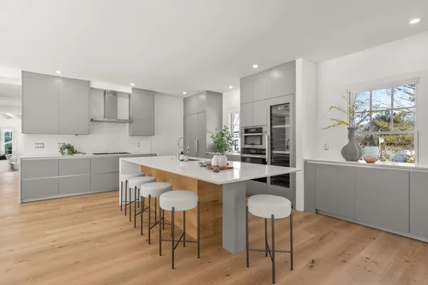 a kitchen with kitchen island a dining table and chairs