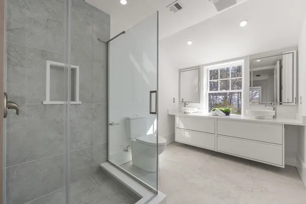a bathroom with a granite countertop sink and a window