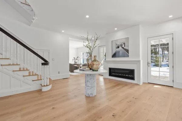 a view of a livingroom with fireplace wooden floor and staircase