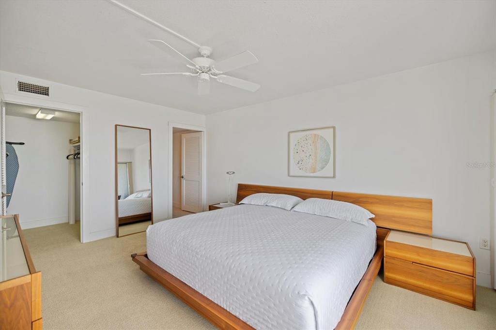 625 Beach Road, Unit 602 Sarasota, FL 34242 - Photo 23 of 65 a bedroom with a bed and a chandelier