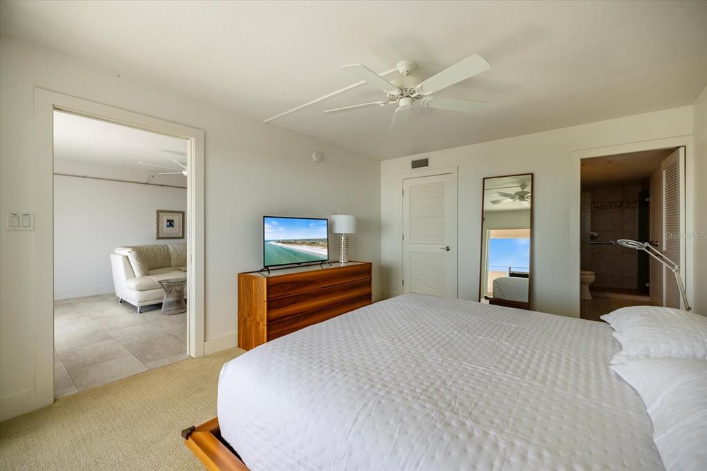 625 Beach Road, Unit 602 Sarasota, FL 34242 - Photo 25 of 65 a bedroom with a bed and a chandelier