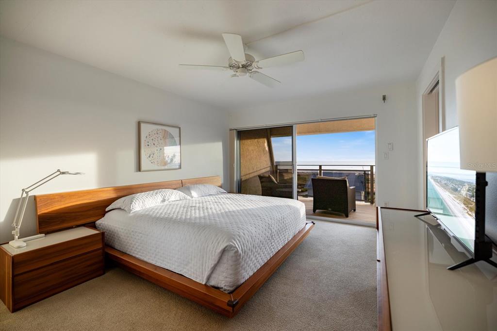 625 Beach Road, Unit 602 Sarasota, FL 34242 - Photo 30 of 65 a bedroom with a bed flat screen tv and a large window