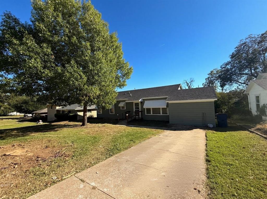 1512 West Day Street Denison, TX 75020 - Photo 2 of 14 a front view of house with yard and car parked