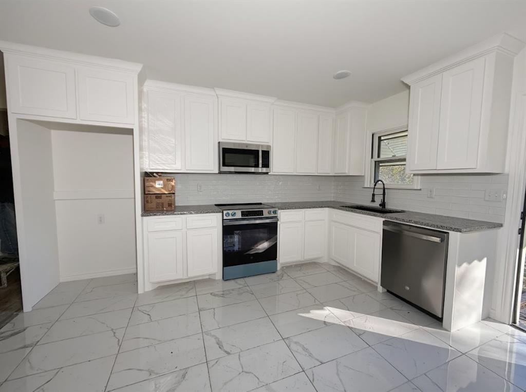 1512 West Day Street Denison, TX 75020 - Photo 5 of 14 a kitchen with a sink and a stove top oven