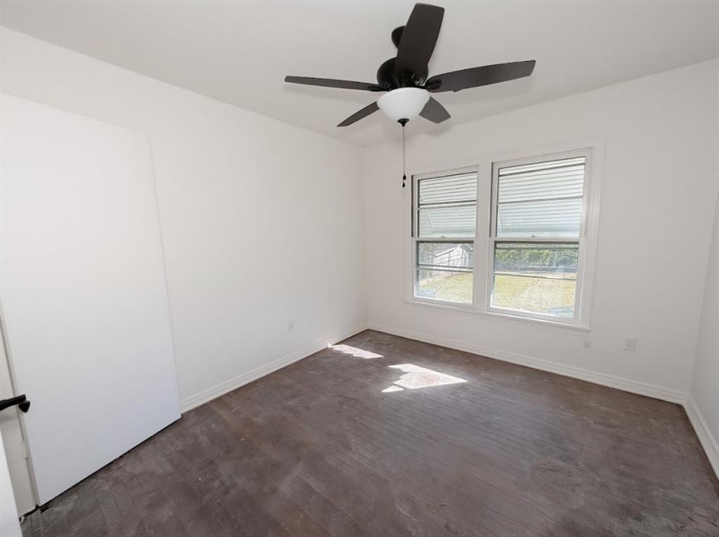 1512 West Day Street Denison, TX 75020 - Photo 8 of 14 an empty room with a window and a ceiling fan