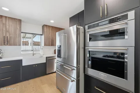 a open kitchen with stainless steel appliances kitchen island a table and chairs in it