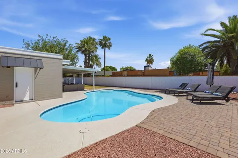 a view of a house with pool and chairs