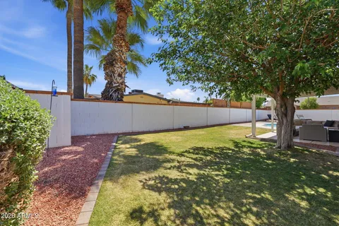a view of a swimming pool with a patio and a yard