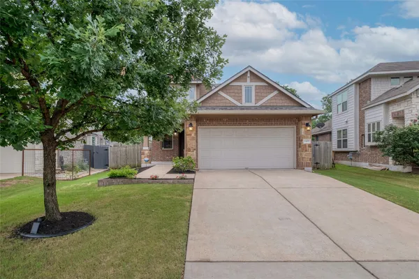 a front view of a house with a yard and trees