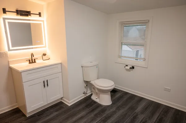 a bathroom with a toilet sink and mirror